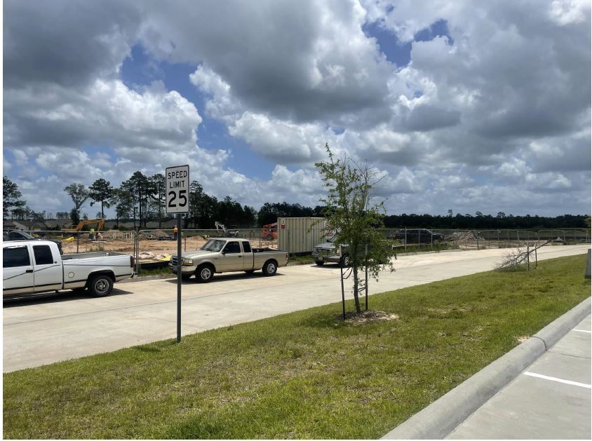 Photo of fence and trucks at construction site